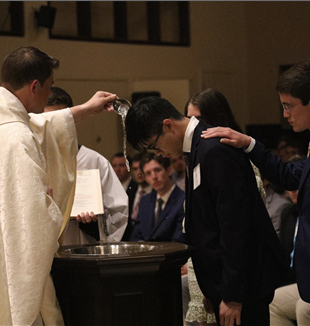 Fr. Branson baptizing Alvin during the 2023 Easter Vigil 